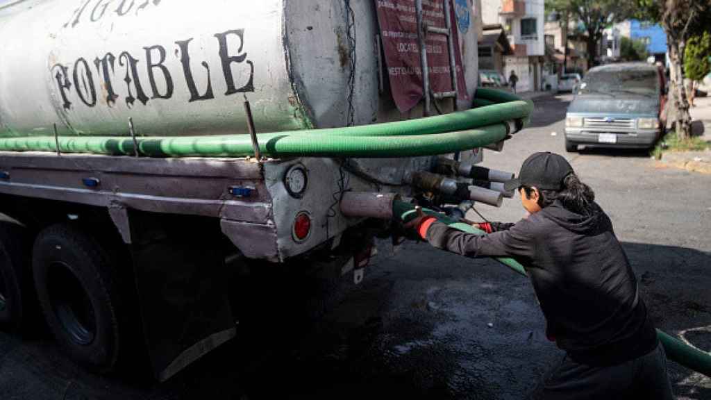 Un camión cisterna distribuye agua potable a los hogares de los capitalinos.