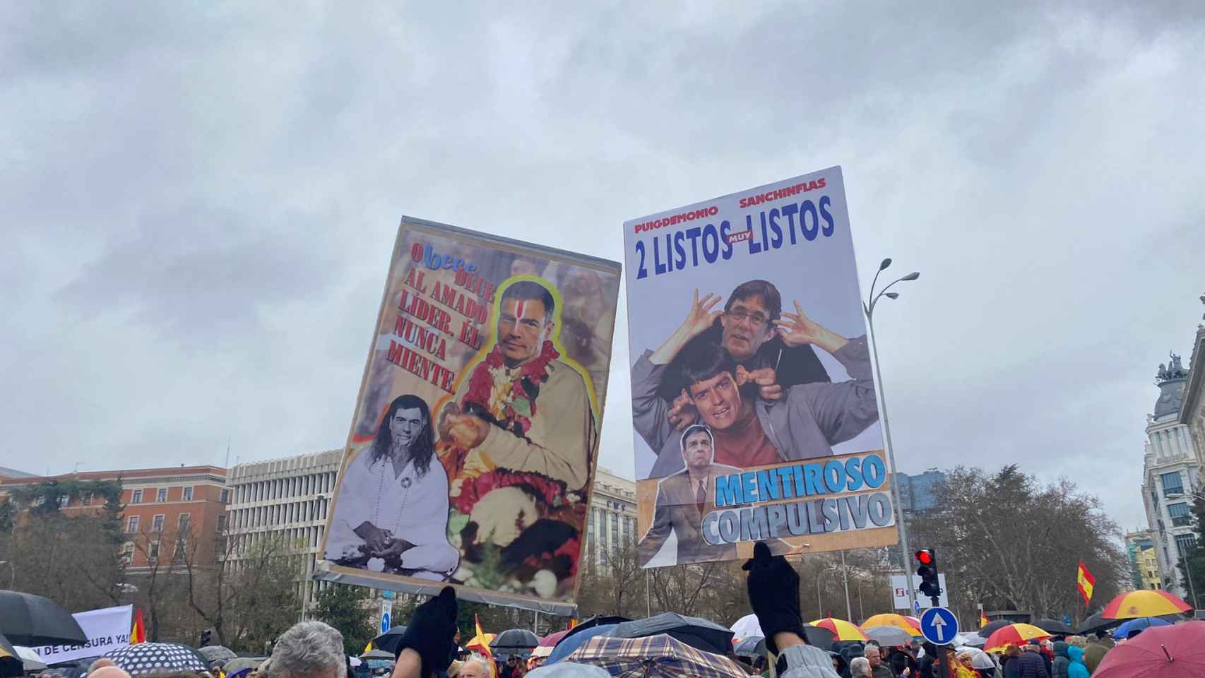 Un manifestante porta carteles contra Sánchez y Puigdemont.