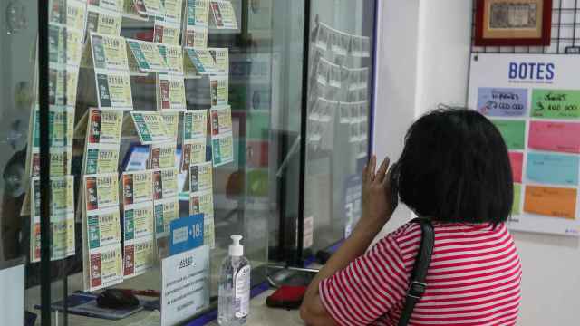 Una mujer compra lotería en una Administración de Lotería.