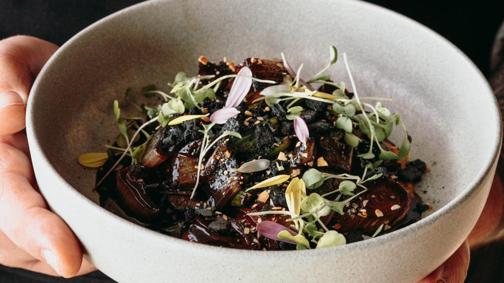 Calçots salteados con ajo negro, merengue ahumado y puré de calabaza.