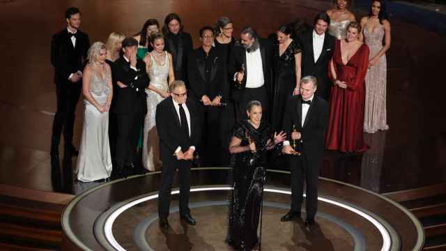 El director Christopher Nolan y los productores Emma Thomas y Charles Roven en el escenario recogiendo el Oscar junto a todo el equipo
