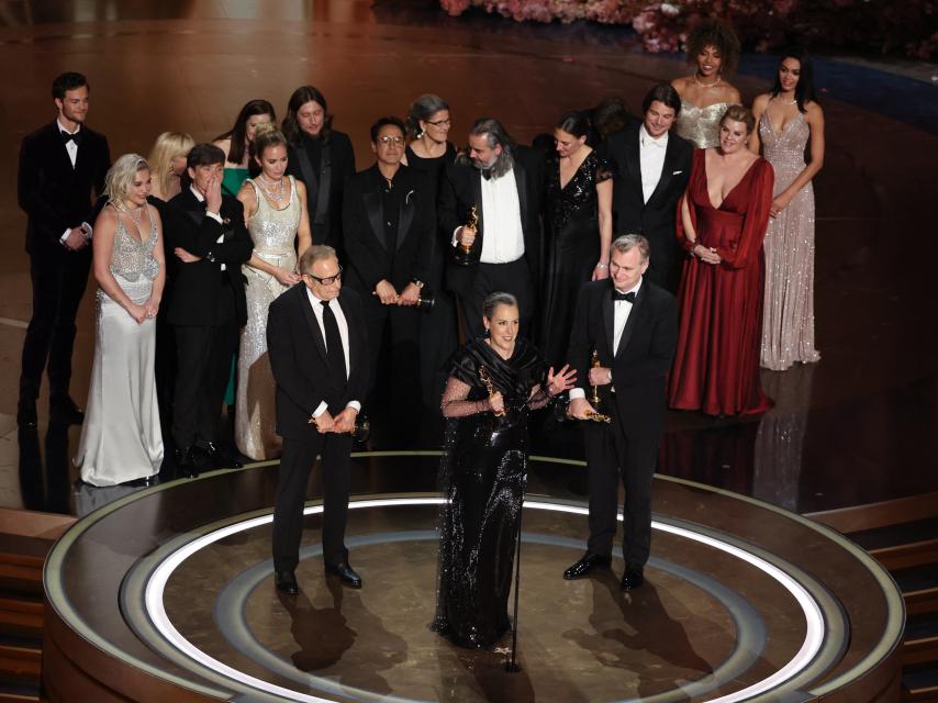 El director Christopher Nolan y los productores Emma Thomas y Charles Roven en el escenario recogiendo el Oscar junto a todo el equipo