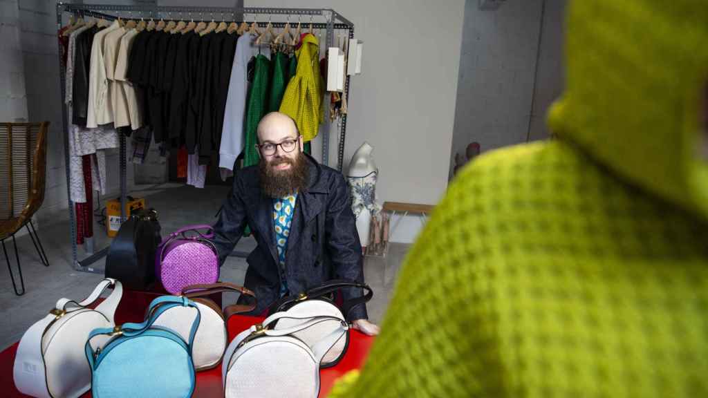 Tristán Ramírez al lado de unos diseños de bolsos de los diseñadores de Caleido Fashion Lab.