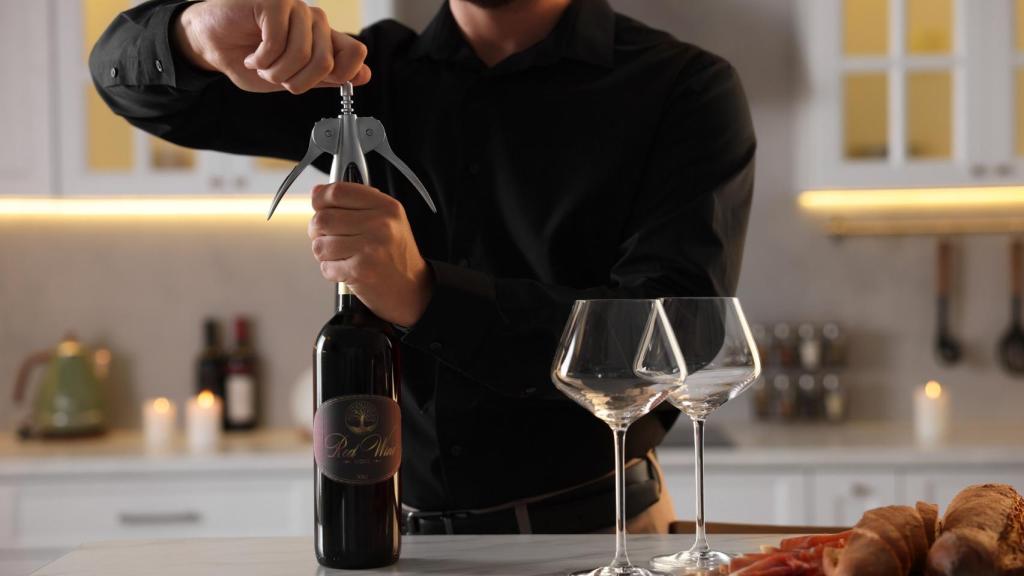 Un hombre abriendo una botella de vino