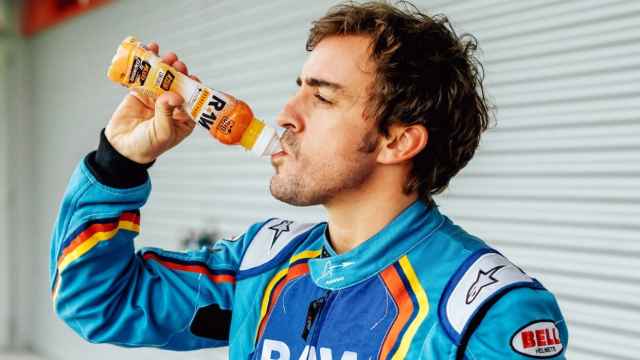 El piloto de Fórmula 1, Fernando Alonso, bebiendo la bebida de naranja y mango de Raw Super Drink.