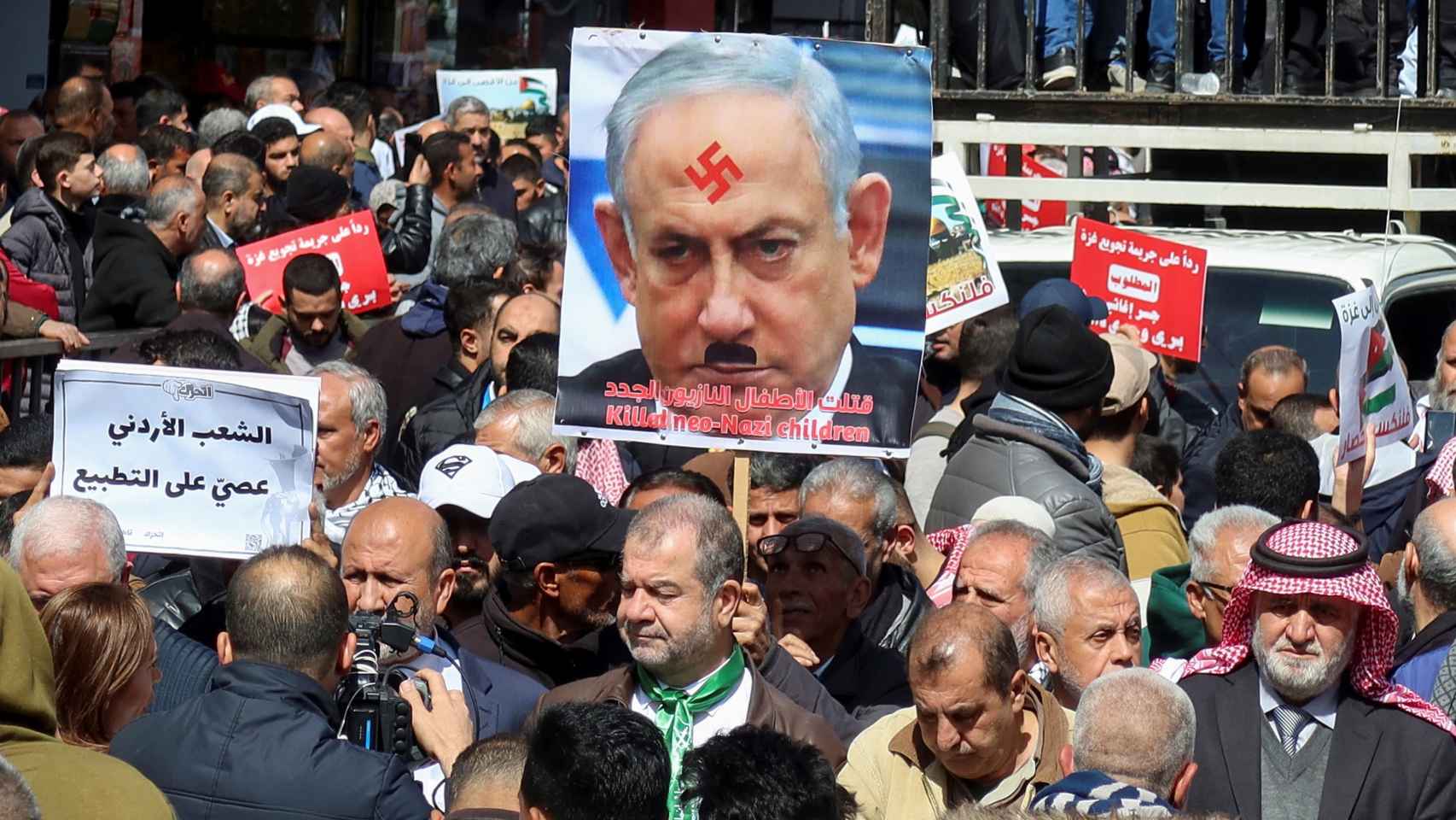 Un hombre porta una fotografía de Netanyahu editada con la esvástica nazi y un bigote similar al de Hitler, en una  manifestación reciente por Gaza en Amman (Jordania).
