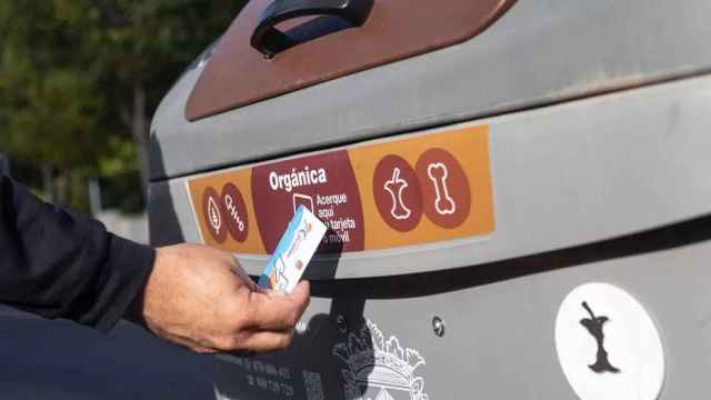 Un vecino de Alicante utiliza su tarjeta identificativa en el contenedor marrón.