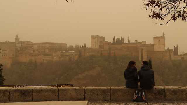 Dos personas observan la Alhambra de Granada desde el mirador de San Nicolás, en 2023.