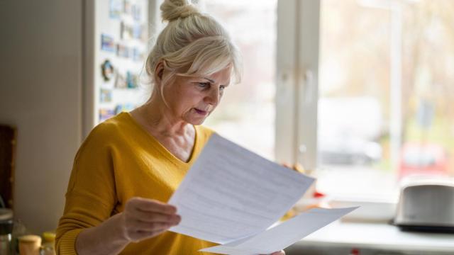 Una pensionista leyendo las condiciones de su plan de pensiones.