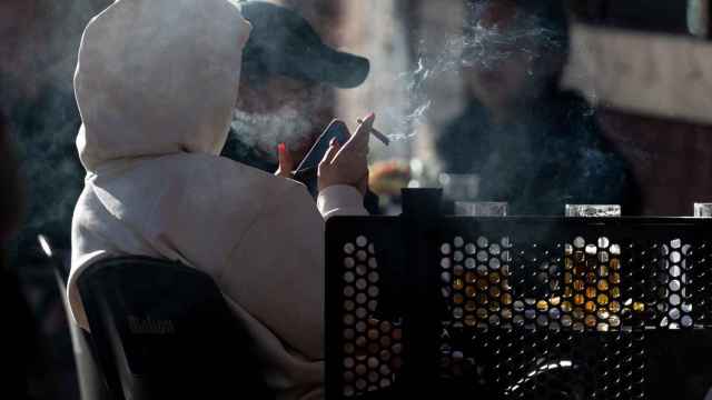 Imagen de archivo de una persona fumando en una terraza.
