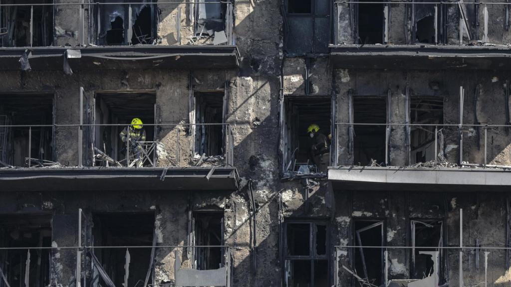 Los bomberos trabajan en el edificio incendiado.