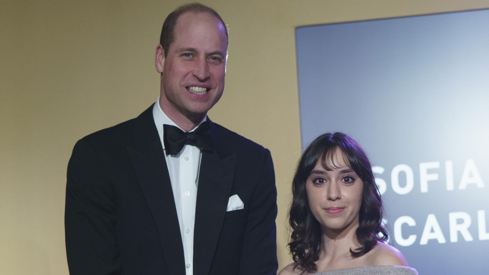 Guillermo de Inglaterra posando, muy sonriente, junto a una de las premiadas.