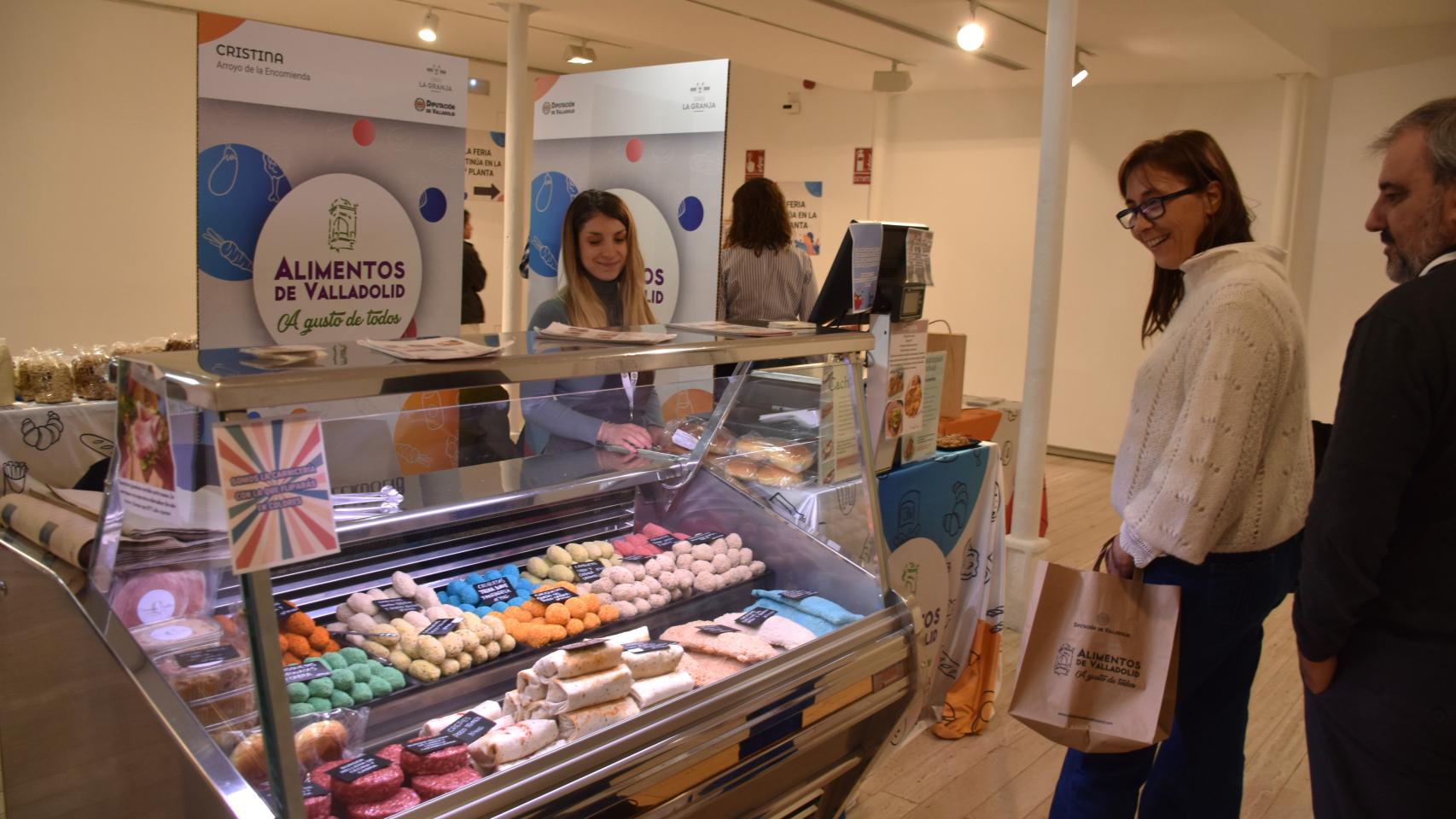 Un expositor de la feria lleno de carne y croquetas de colores