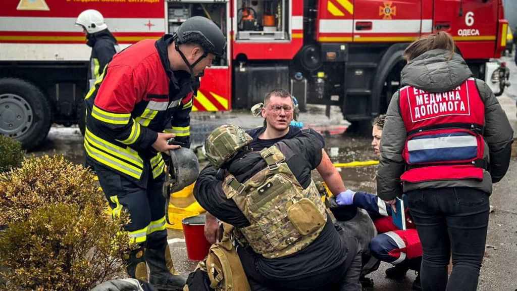 Varios rescatistas asisten a un compañero herido en el lugar de un ataque con misiles rusos, el viernes en Odesa.