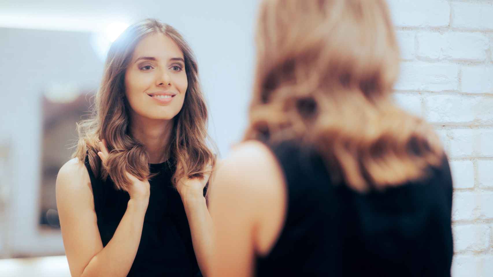 Imagen de archivo de una mujer mirándose al espejo en la peluquería.