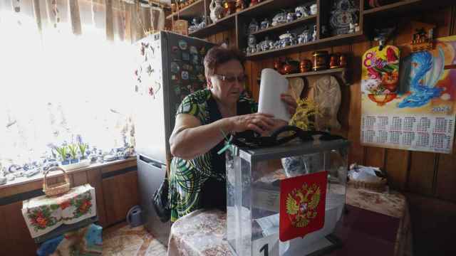 Una rusa emite su voto en su hogar en Moscú gracias al comité electoral móvil.