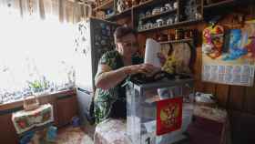 Una rusa emite su voto en su hogar en Moscú gracias al comité electoral móvil.