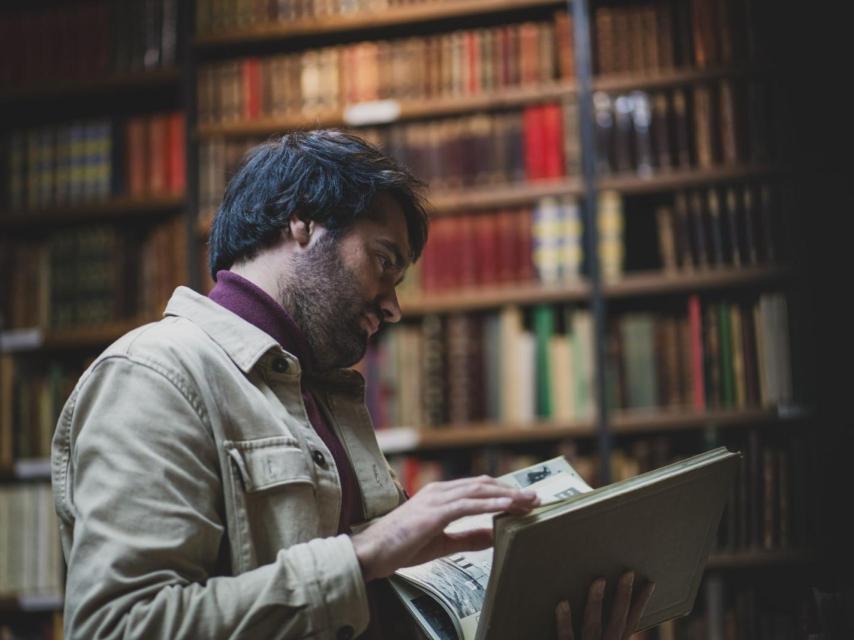 Daniel Ramírez hojea un libro.