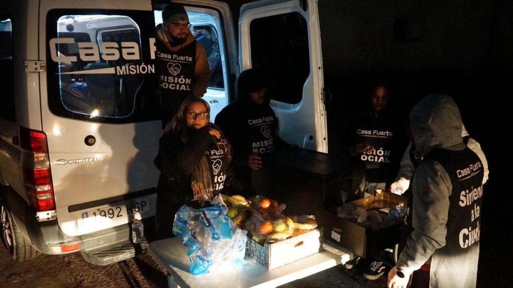 Los voluntarios de Casa Fuerte reparten las bolsas de alimentos a los vecinos.