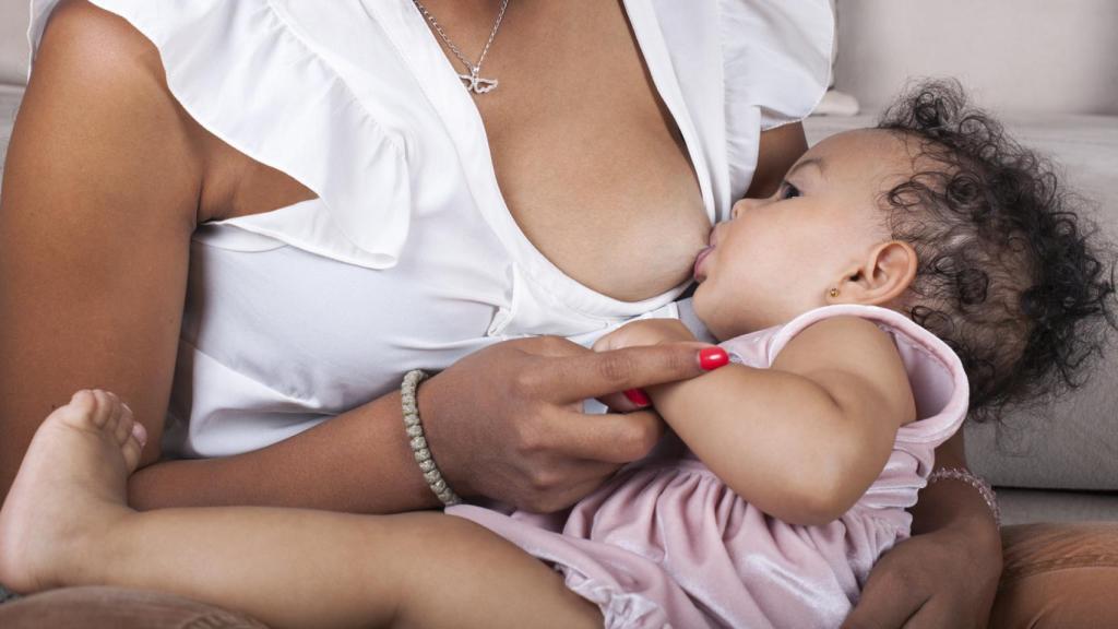 Una mujer amamantando a su hijo.