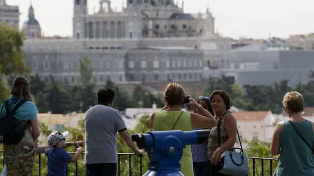 Varias personas observan las vistas del Palacio Real y la catedral de la Almudena desde los jardines del templo de Debod, en Madrid.