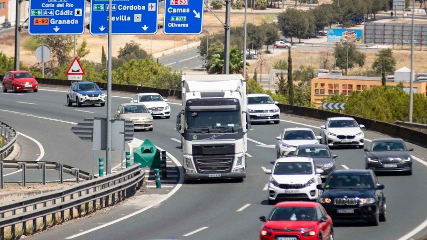 Varios vehículos desplazándose por una carretera española.