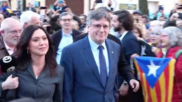 Carles Puigdemont accede junto a su esposa, Marcela Topor, al Ayuntamiento de Elna (Francia), rodeado de seguidores, este jueves.