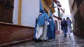 Dos nazarenos de San Esteban caminan bajo la lluvia en la Semana Santa de 2022.