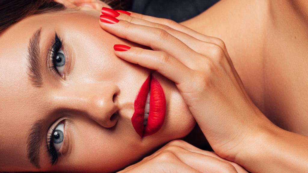 Mujer de ojos azules con la mano en la cara.