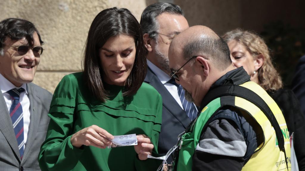 La reina Letizia compra un cupón a un vendedor de la ONCE para apoyar a la organización.