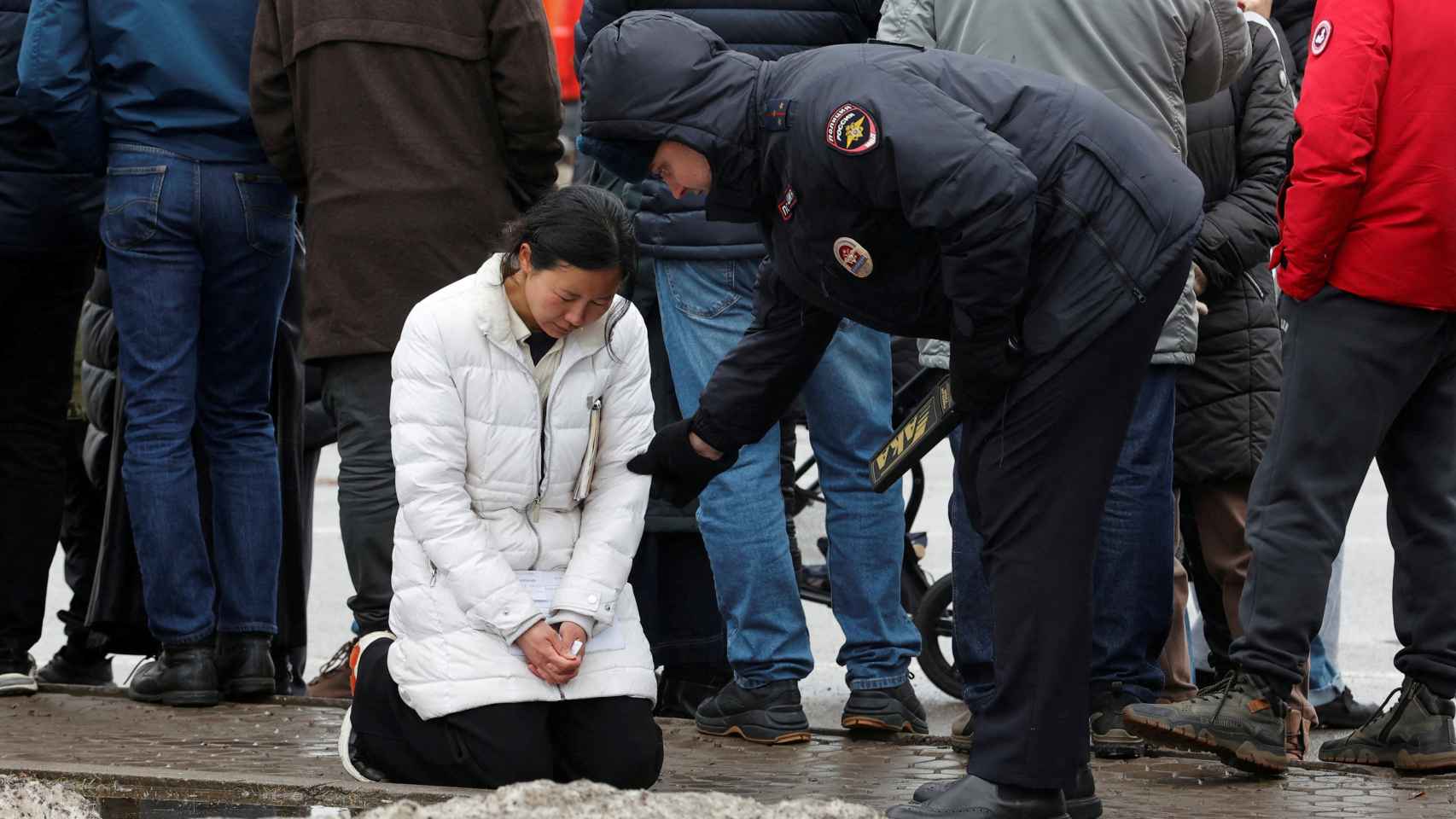 Un policía se acerca a una mujer fuera del Crocus City Hall, este sábado en Moscú.