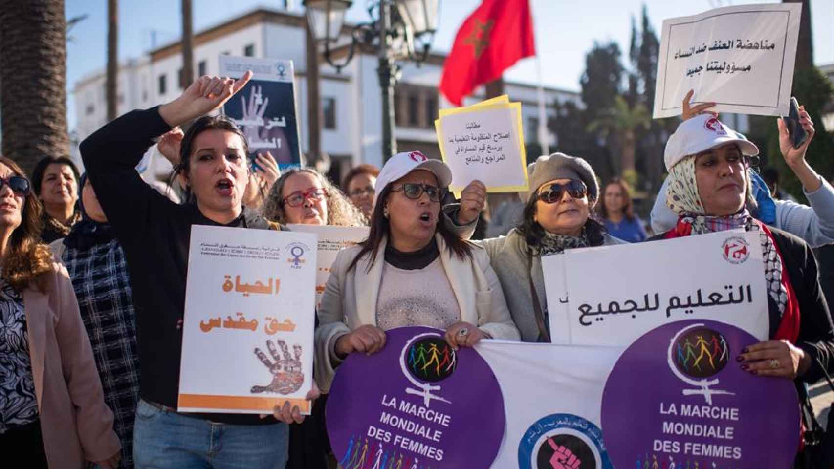 Mujeres sostienen pancartas durante el Día Internacional de la Mujer frente al edificio del Parlamento en Rabat, Marruecos.