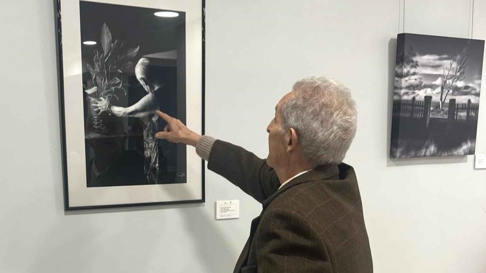 Un hombre disfrutando de la exposición fotográfica en la residencia palentina