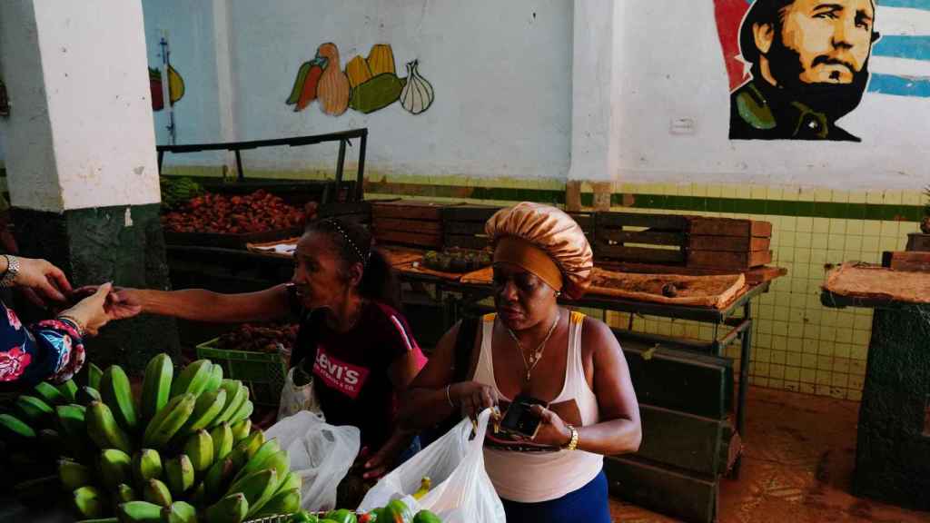 Una mujer compra fruta en La Habana mientras los cubanos esperan la prometida intervención del Gobierno.