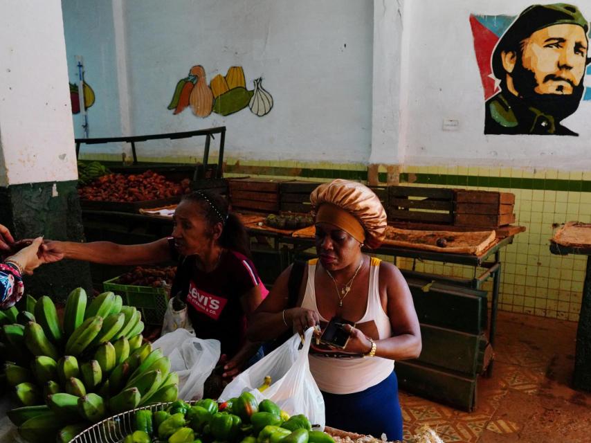 Una mujer compra fruta en La Habana mientras los cubanos esperan la prometida intervención del Gobierno.