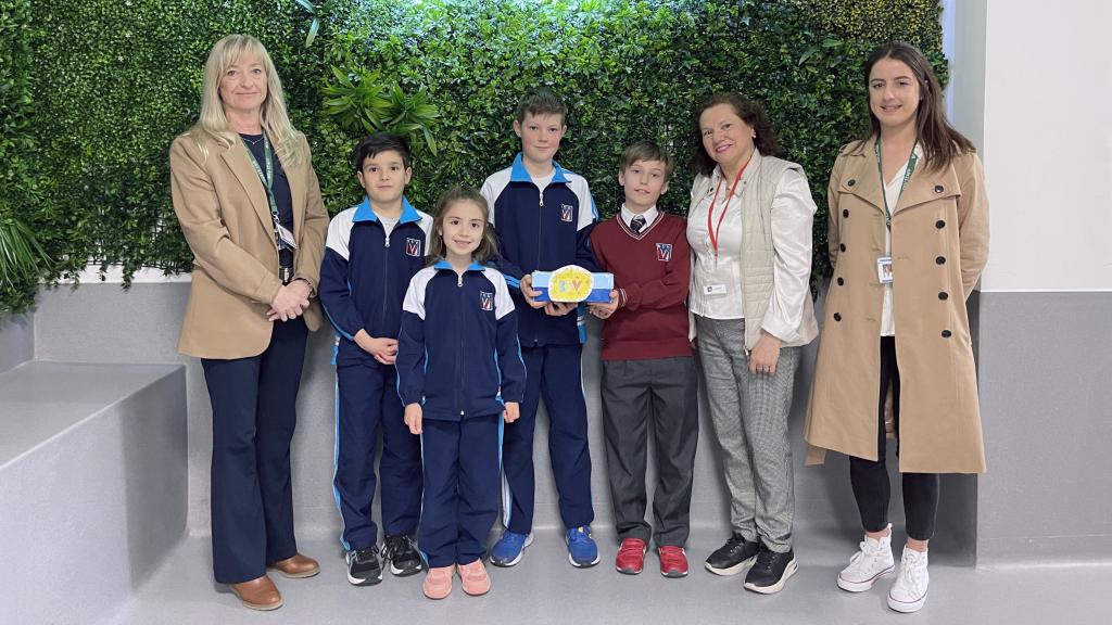 Alumnos ganadores del concurso entregan el dinero a la responsable de Amigos de la Calle. EE