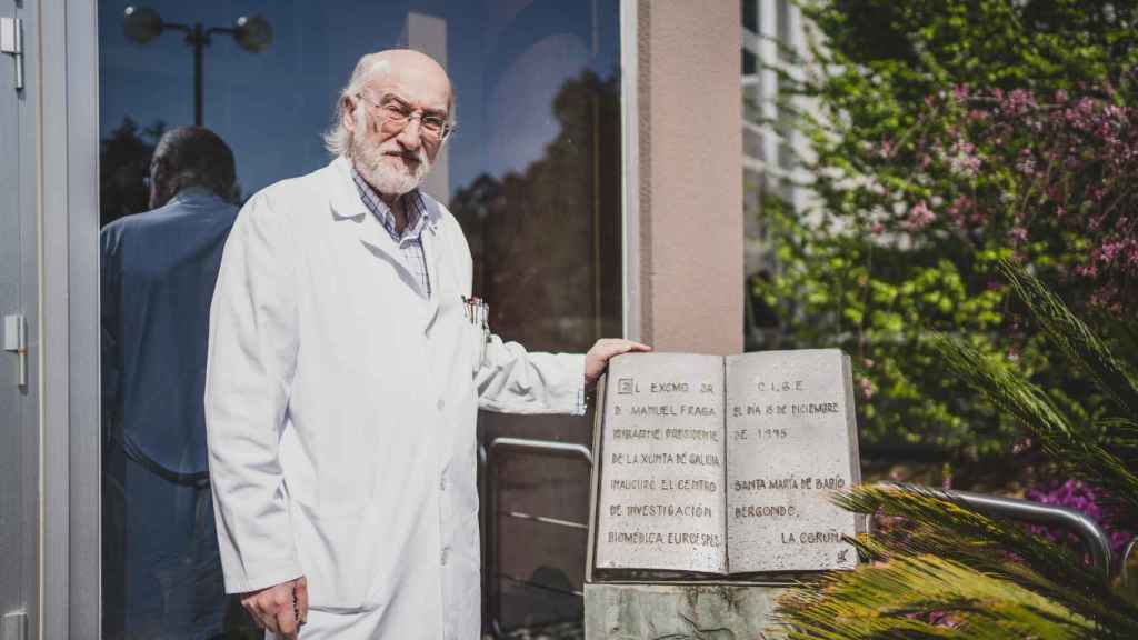 El doctor Cacabelos en la fachada del Centro de Neurociencias y Medicina Genómica EuroEspes, posando al lado de una placa inaugural firmada por Manuel Fraga.