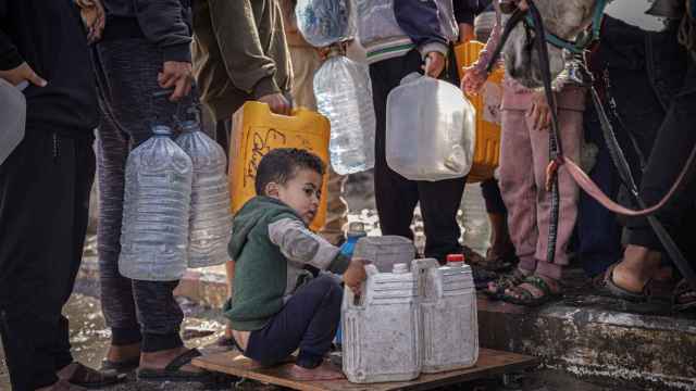 Palestinos de todas las edades colectan agua en la Franja de Gaza, asediada por Israel desde el pasado octubre.