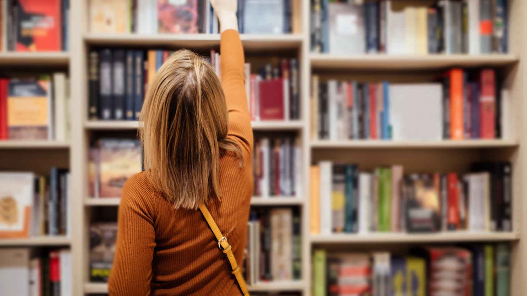 Una mujer leyendo en una librería.