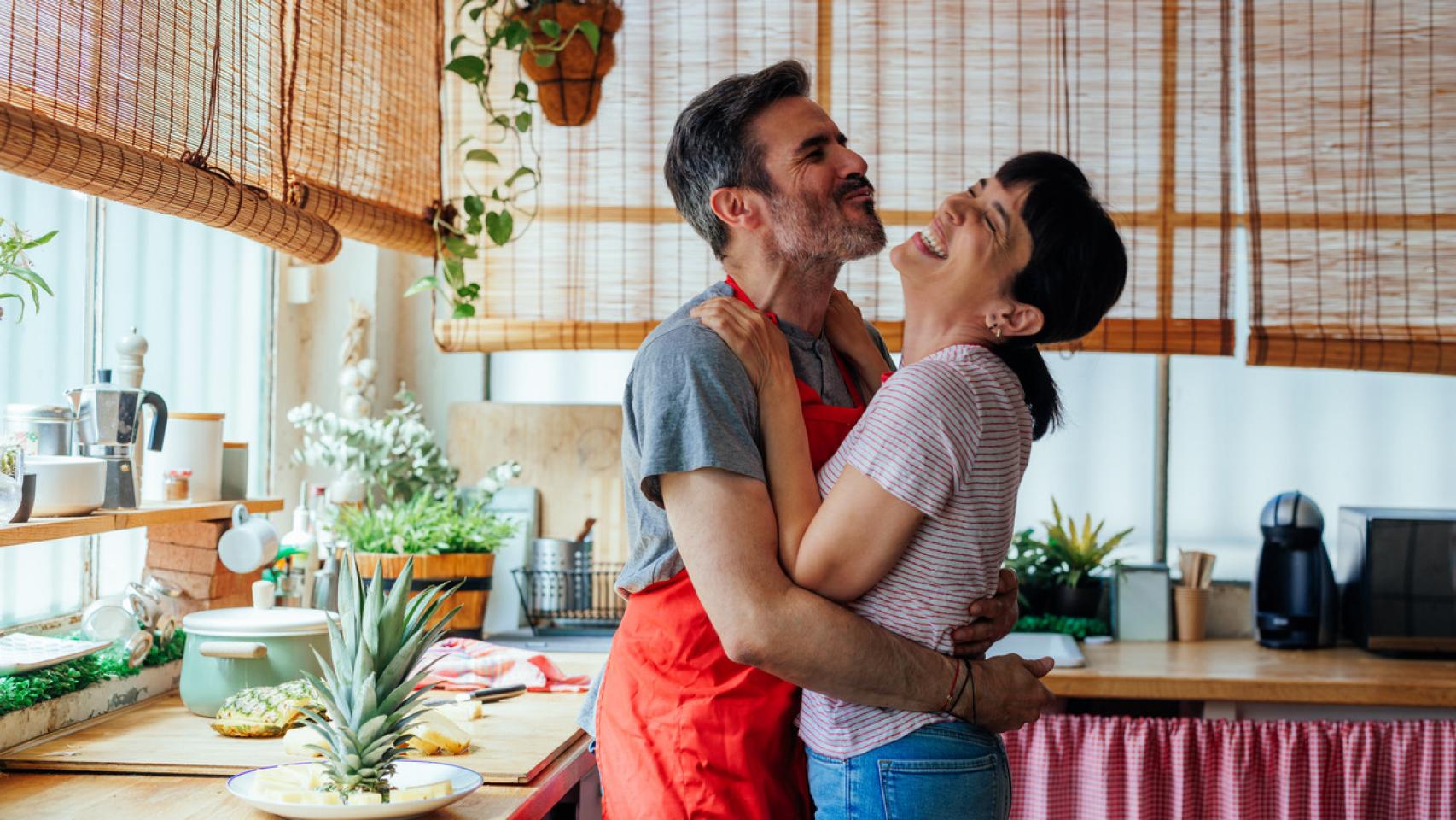 Una pareja se abraza en la cocina.