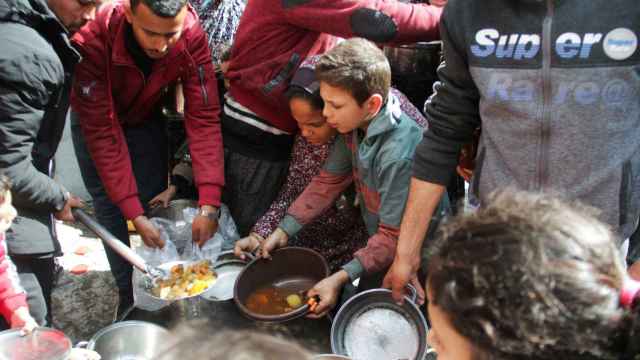 Palestinos se reúnen para recibir comida gratuita en Jabalia, en el norte de la Franja de Gaza, 19 de marzo de 2024. (Reuters/Mahmoud Issa)