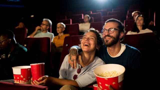 Una pareja joven disfruta de una divertida película en el cine.