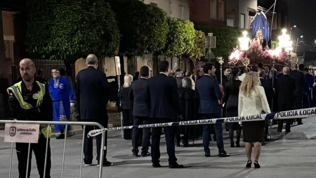 En empleado de una empresa de seguridad privada, vigilando que se respete el corte del tráfico de una calle, para garantizar el paso de una procesión en Las Torres de Cotillas.