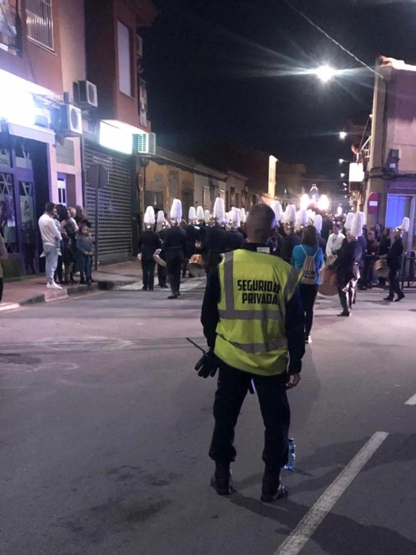 Un empleado de seguridad privada vigilando el transcurso de una procesión en Las Torres de Cotillas.