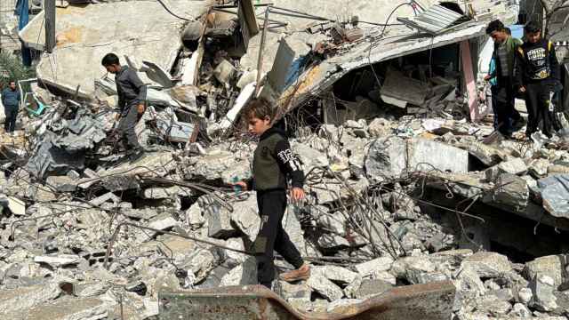 Menores de edad caminan entre los escombros en Gaza