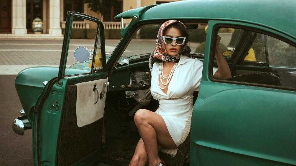 Una mujer con apariencia millonaria bajando de un coche, en una imagen de stock.