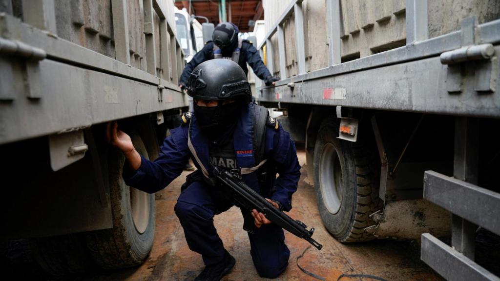 Miembros de la Armada de Ecuador inspeccionan un barco y su carga durante una patrulla fluvial, Guayaquil.