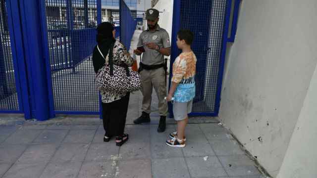Una mujer y un niño muestran sus pasaportes en la frontera del Tarajal, en Ceuta.