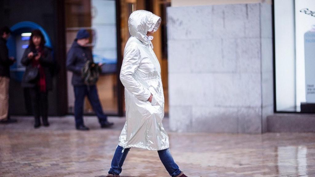 Una mujer camina bajo la lluvia.