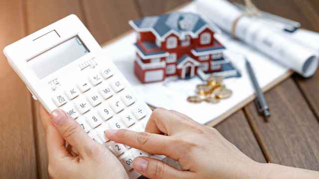 Símil de una persona haciendo cálculos para comprar vivienda.